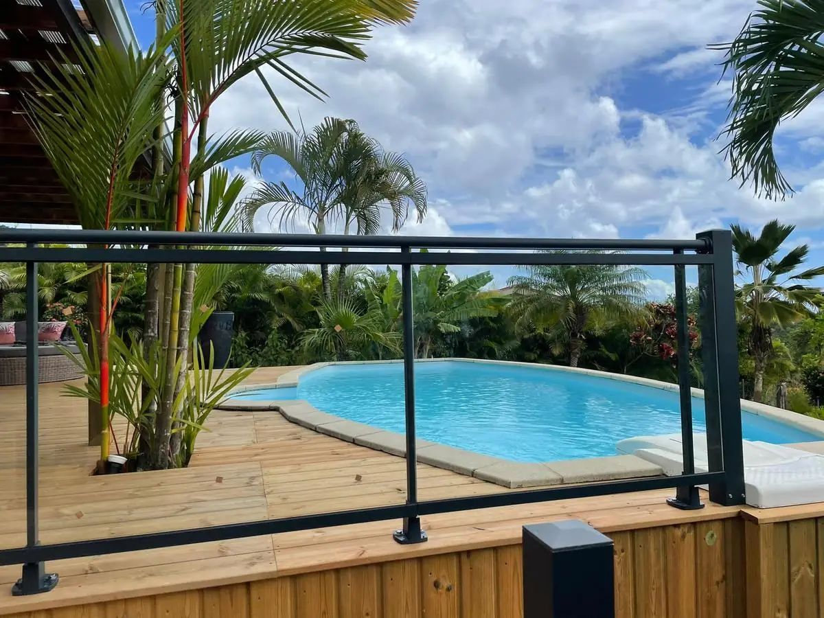 Garde-corps vitré avec main courante autour d'une piscine